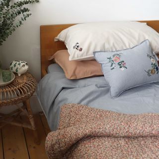 Bed with red patterned duvet and blue check sheets