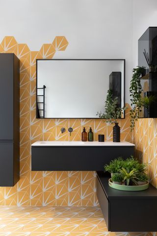 Yellow flooring and wallpeper in duck foot design with contrasting black cabinets and black mirror frame