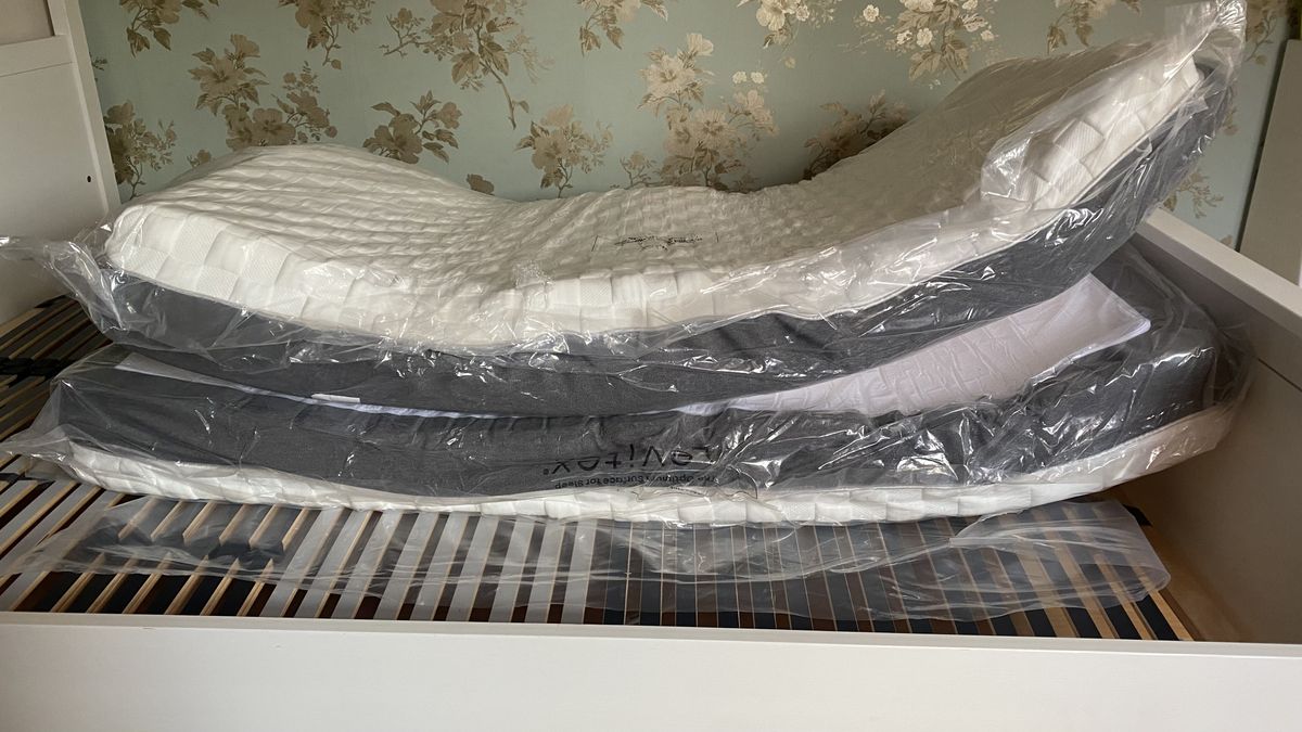 Levitex Gravity Defying Mattress review image shows the mattress unfolding and expanding on a white wooden bed