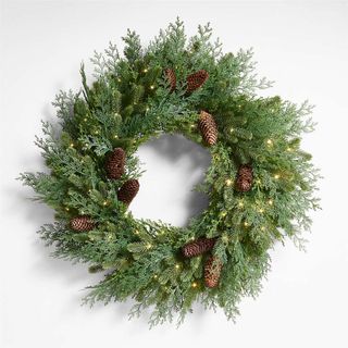 green faux wreath with pinecones and lights