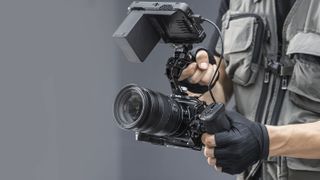SmallRig cage kit for the Nikon ZR, attached to camera and held by videographer