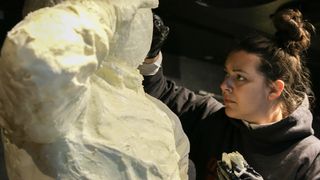 Erin Swearingen smooths the butter on a life-size sculpture of Neil Armstrong.