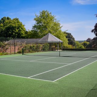 tennis court with synthetic turf surrounded by net