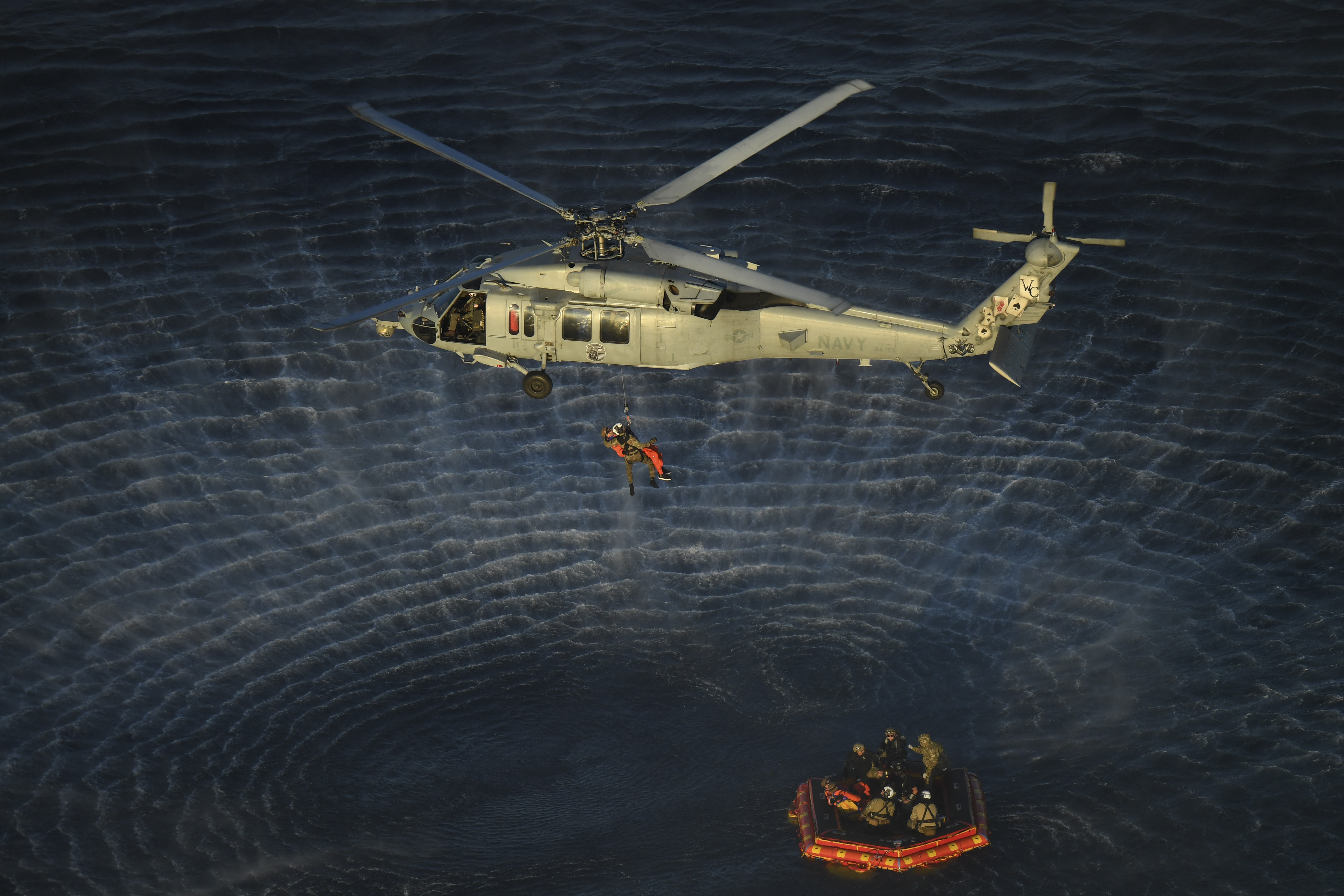 NASA Artemis II crew members are hoisted into a U.S. Navy MH-60 helicopter after successfully splashing down in the Pacific Ocean following their 10-day mission around the Moon.