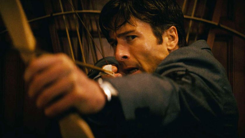 A close up of Becket holding a bow and arrow in How to Make a Killing