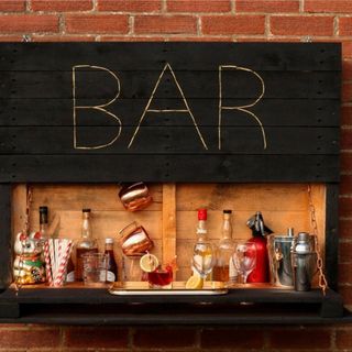 black wooden pallet sign with the word 'bar' and glasses and alcohol bottles