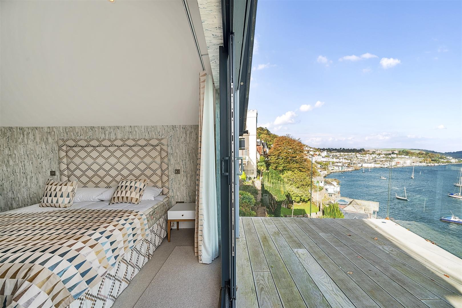 A bedroom with balcony with sea views