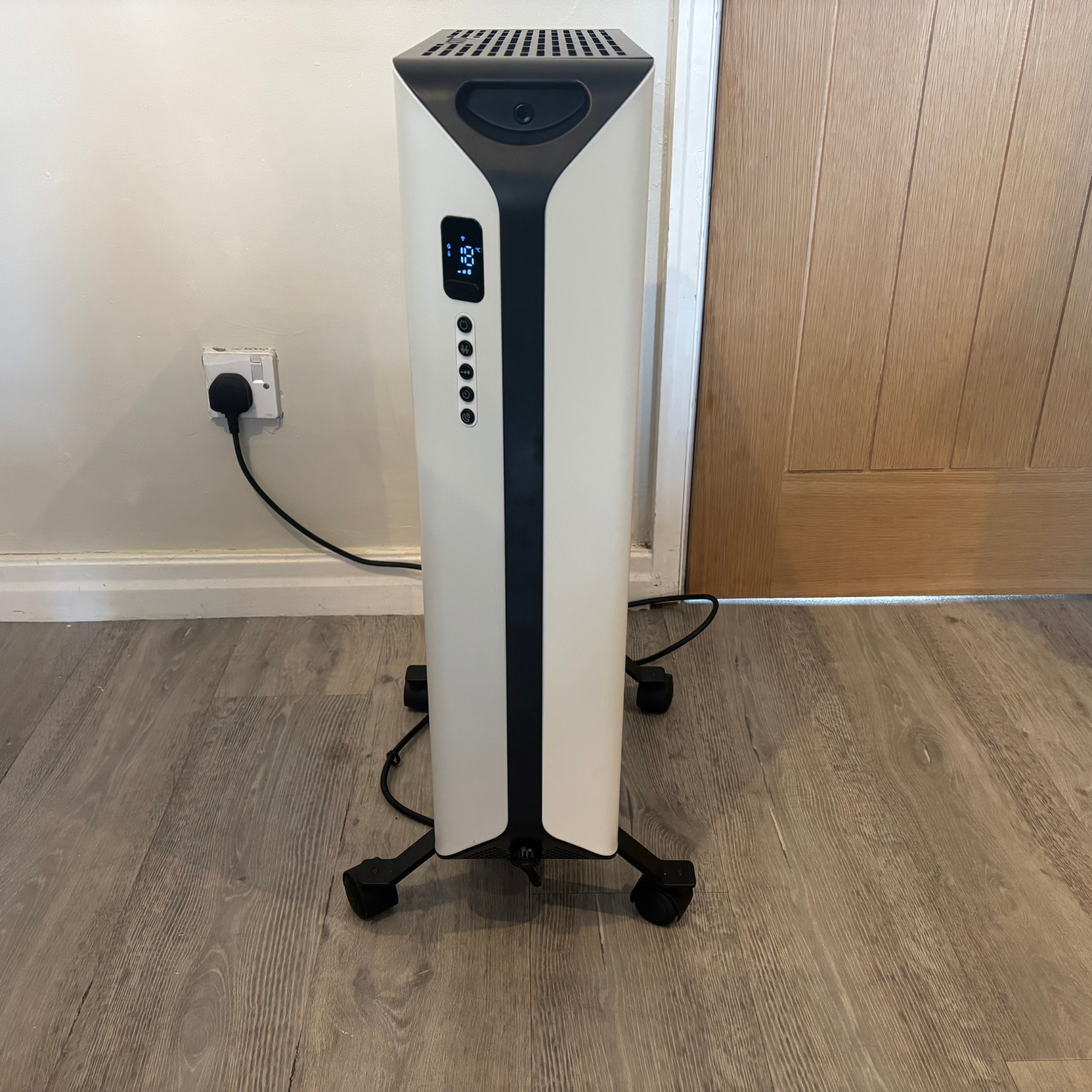 side profile view of the Duux Edge Oil 2000W Oil-Filled Radiator showing LED digital display and power cord plugged into mains