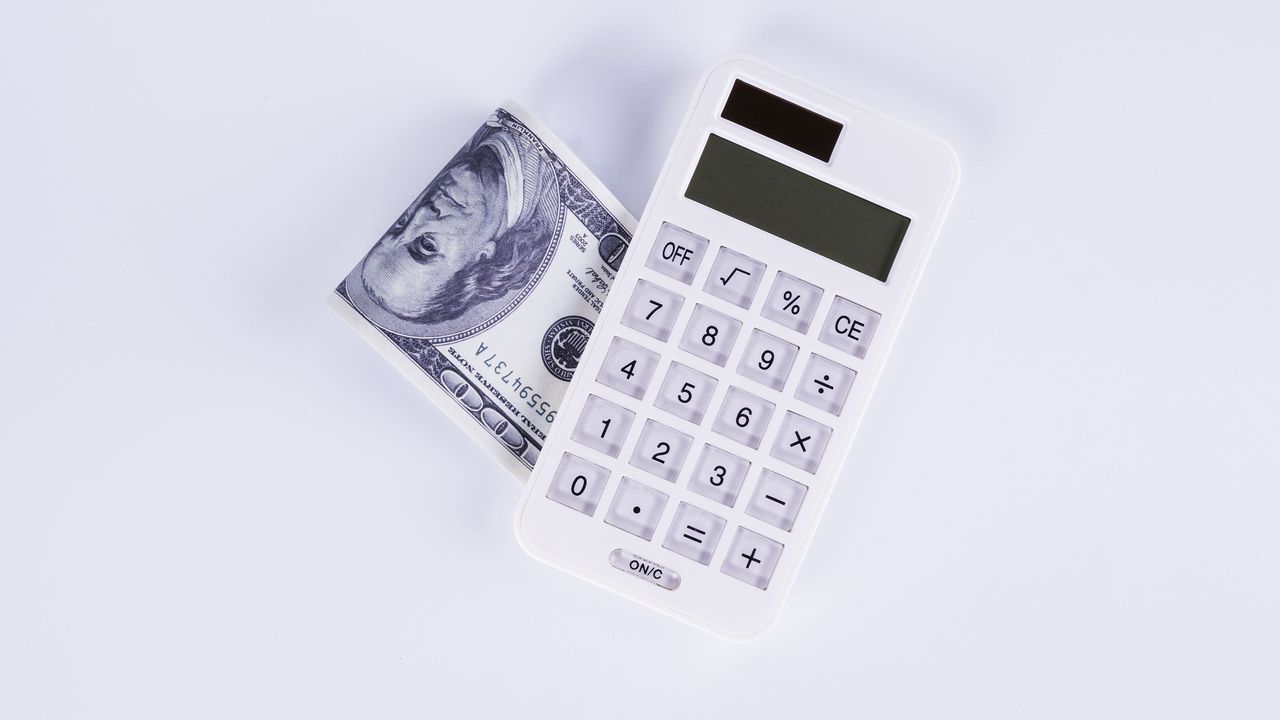 calculator next to folded dollar bills