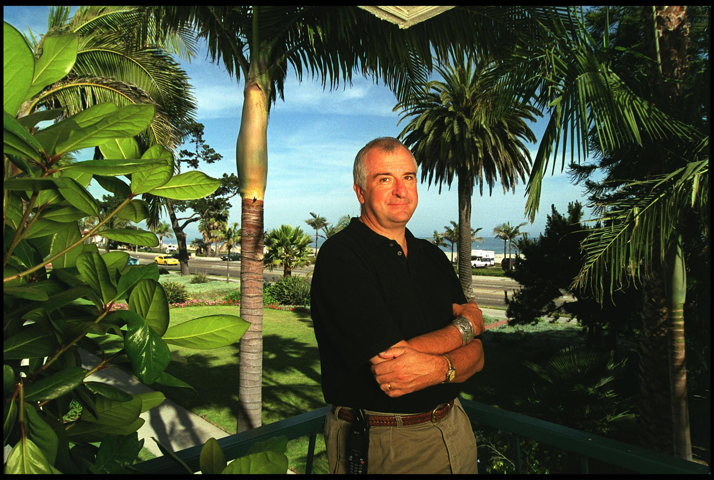 a man on a beach surrounded by palm trees