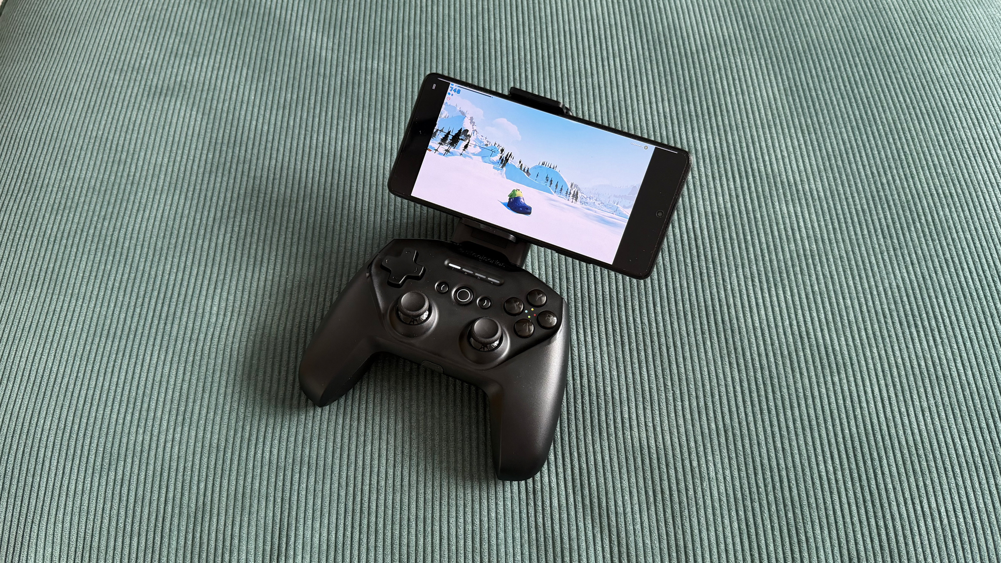 The SteelSeries Stratus+ mobile and PC controller on top of a green carpet surface