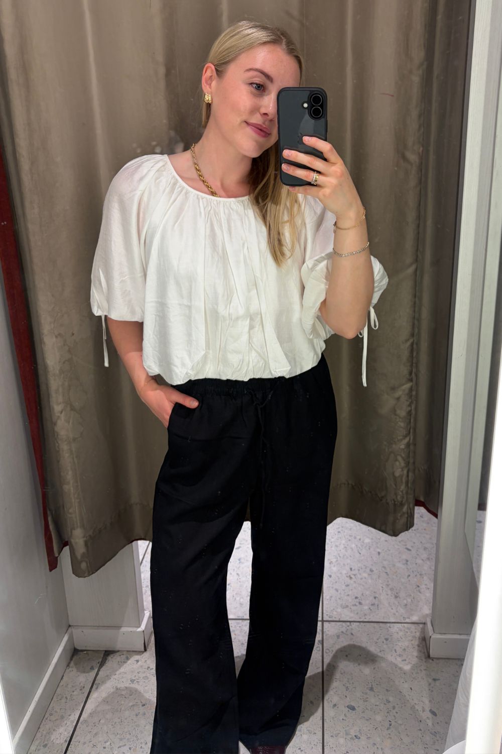 woman wears white top, black linen-blend trousers