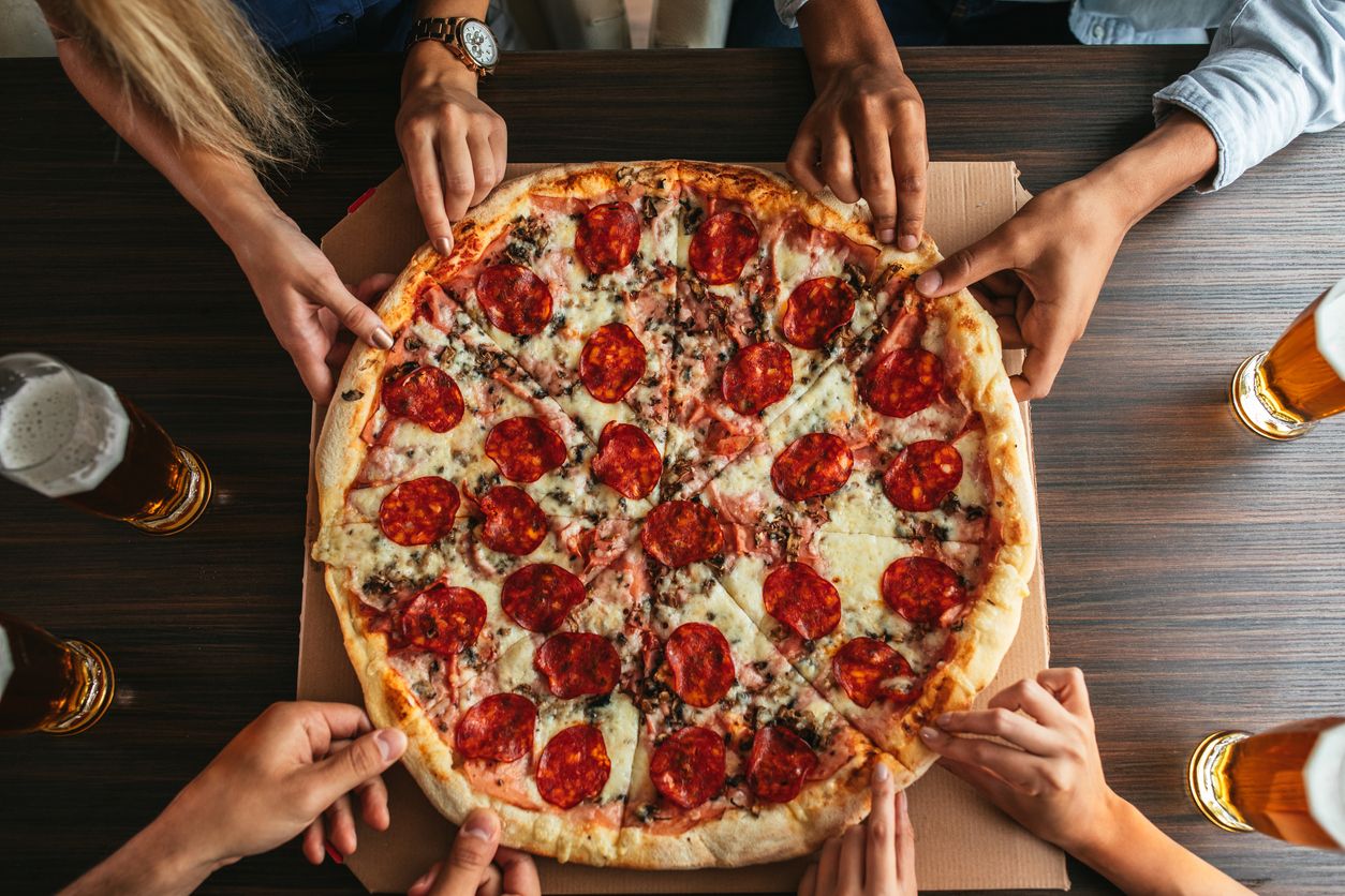 Diners grab pizza slices.