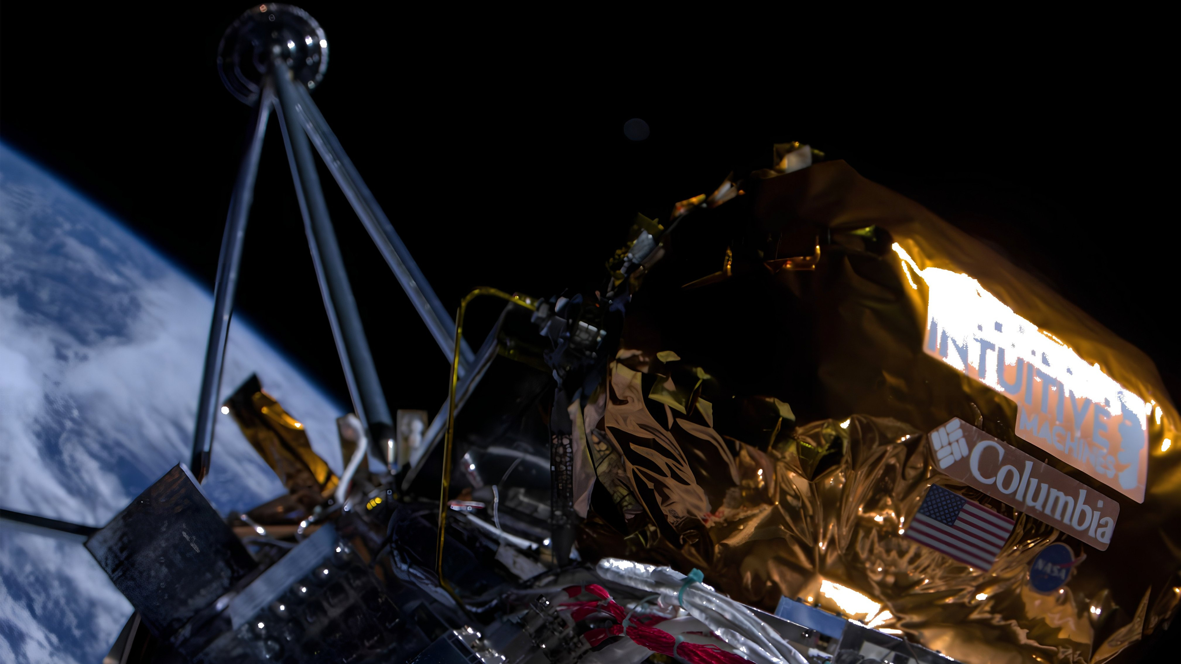 closeup of a spacecraft selfie showing a payload wrapped in gold foil, with the curve of earth in the background.