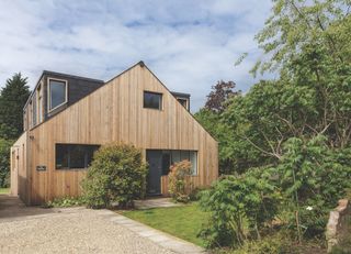 remodelled bungalow with timber cladding and gravel driveway