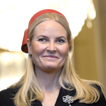 Queen Mette-Marit wearing a red hat