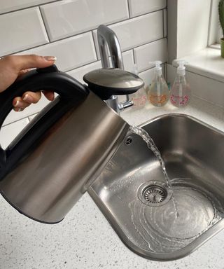Christina Chrysostomou pouring water from electric kettle down the sink
