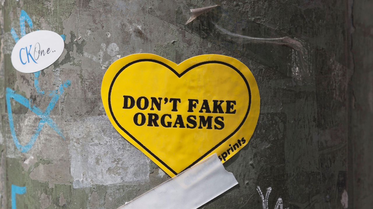 yellow heart-shaped sticker that says &quot;Don&#039;t fake orgasms&quot;