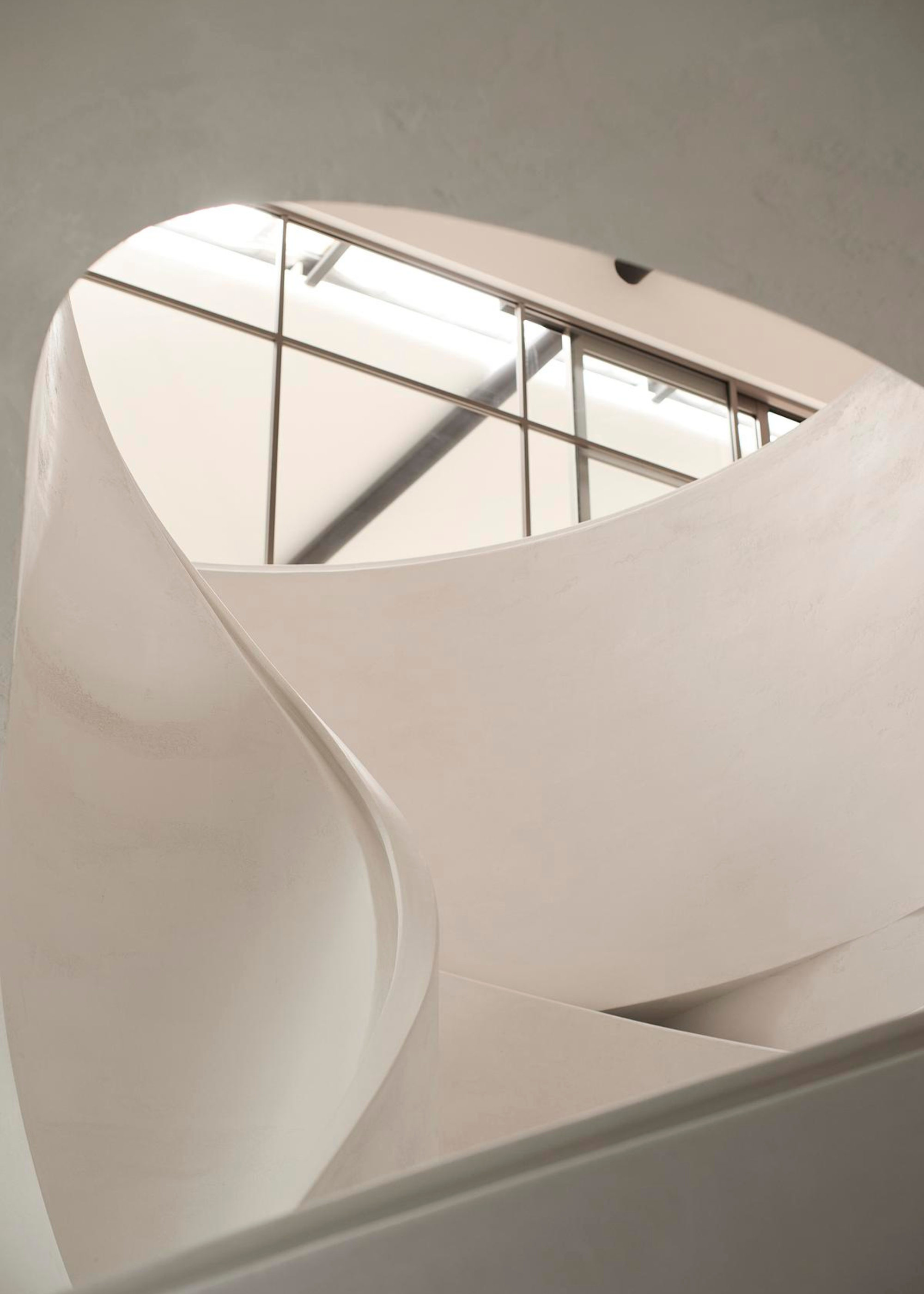 curving white staircase with a shiny smooth banister