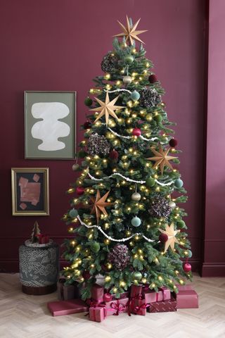 a tall christmas tree decorating with baubles and stars