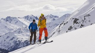 Two skiers on telemark skis travel up a mountain