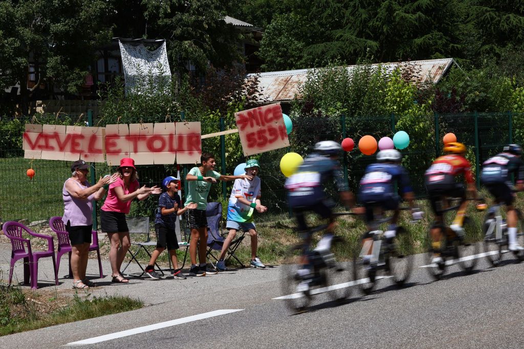 Spectators cheer the breakaway during the 17th stage of the 111th edition of the Tour de France cycling race, 177,8 km between Saint-Paul-Trois-Chateaux and Superdevoluy, southern France, on July 17, 2024. (Photo by Anne-Christine POUJOULAT / AFP)