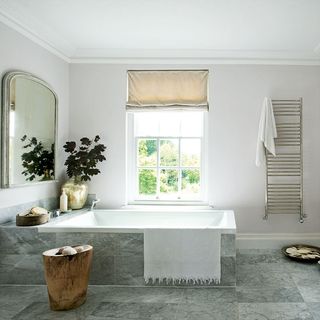 bathroom with white bathtub mirror and white window
