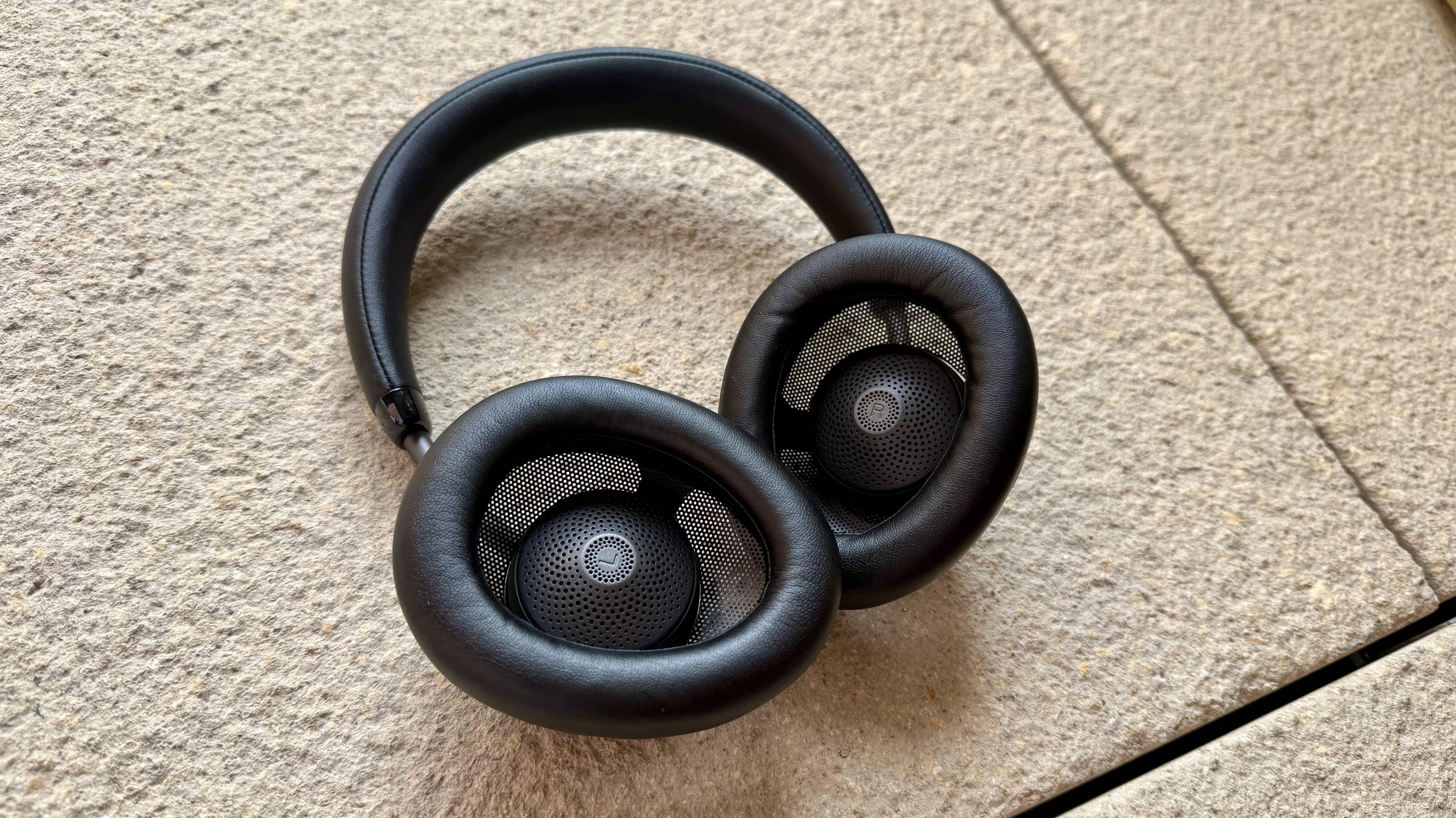 The jlab jbuds open wireless headphones pictured on a stone surface