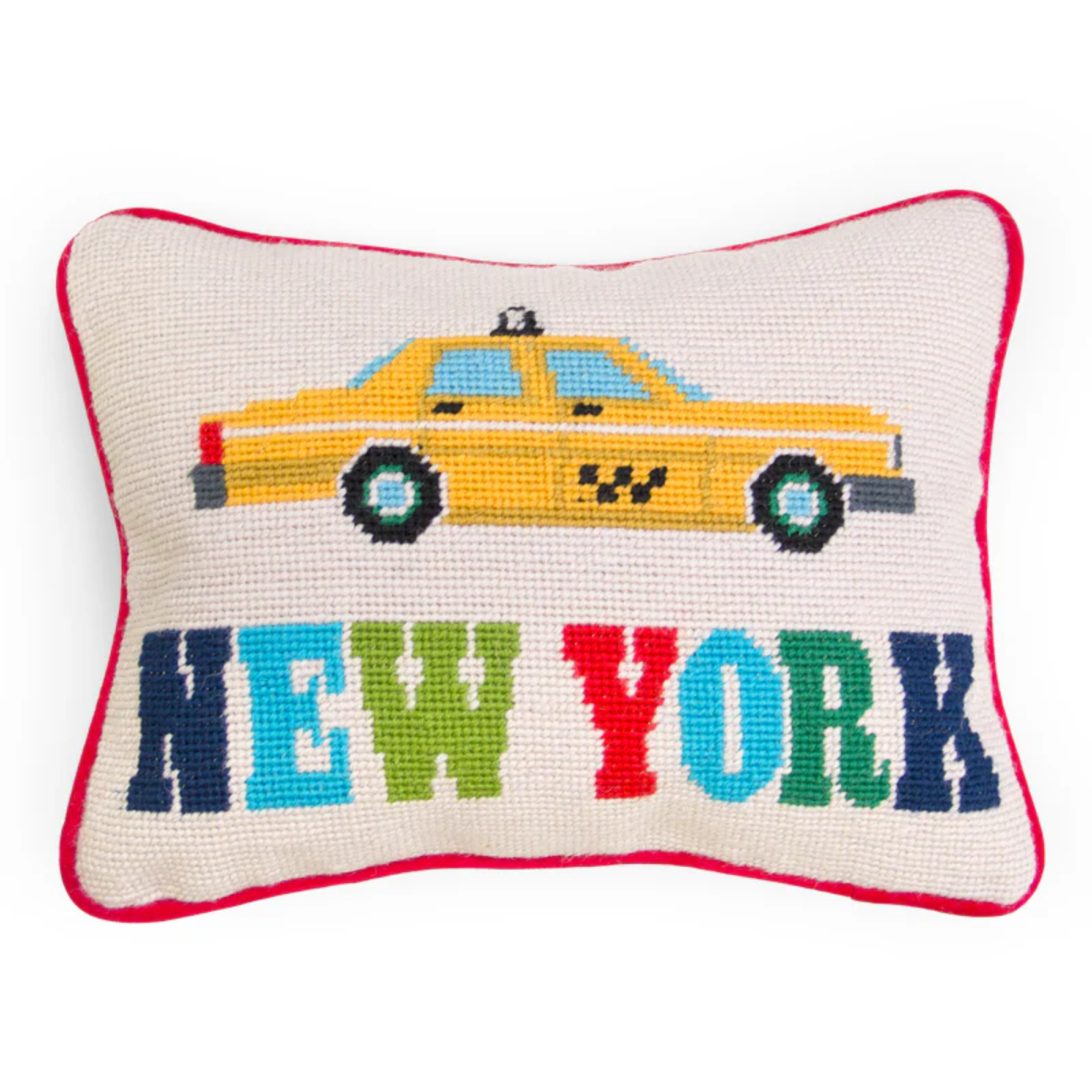a needlepoint pillow that features a taxi cab and says 'New York'