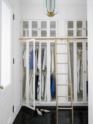 Small white walk in closet with glass doors