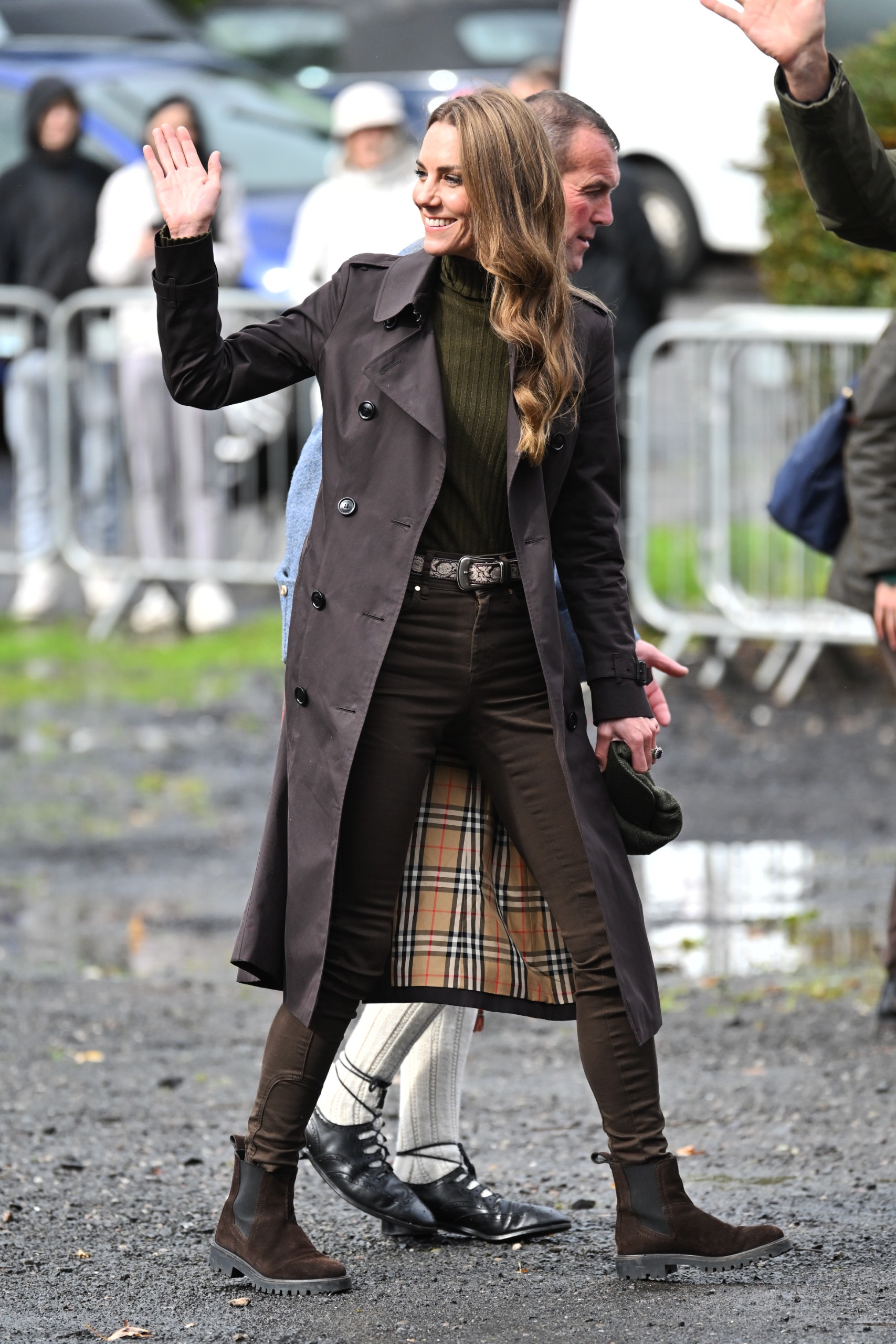 Princess Kate waving in a brown trench and skinny jeans