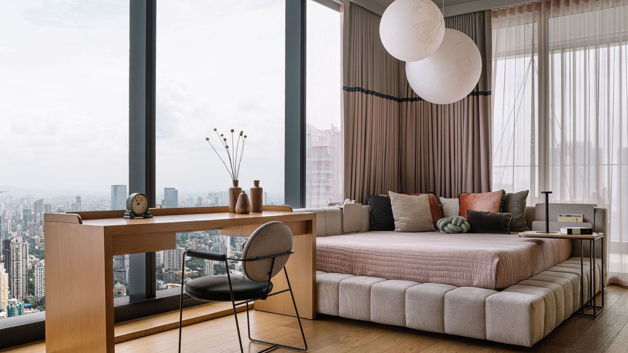 A small bedroom with a work desk, and a corner bed