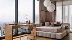 A small bedroom with a work desk, and a corner bed