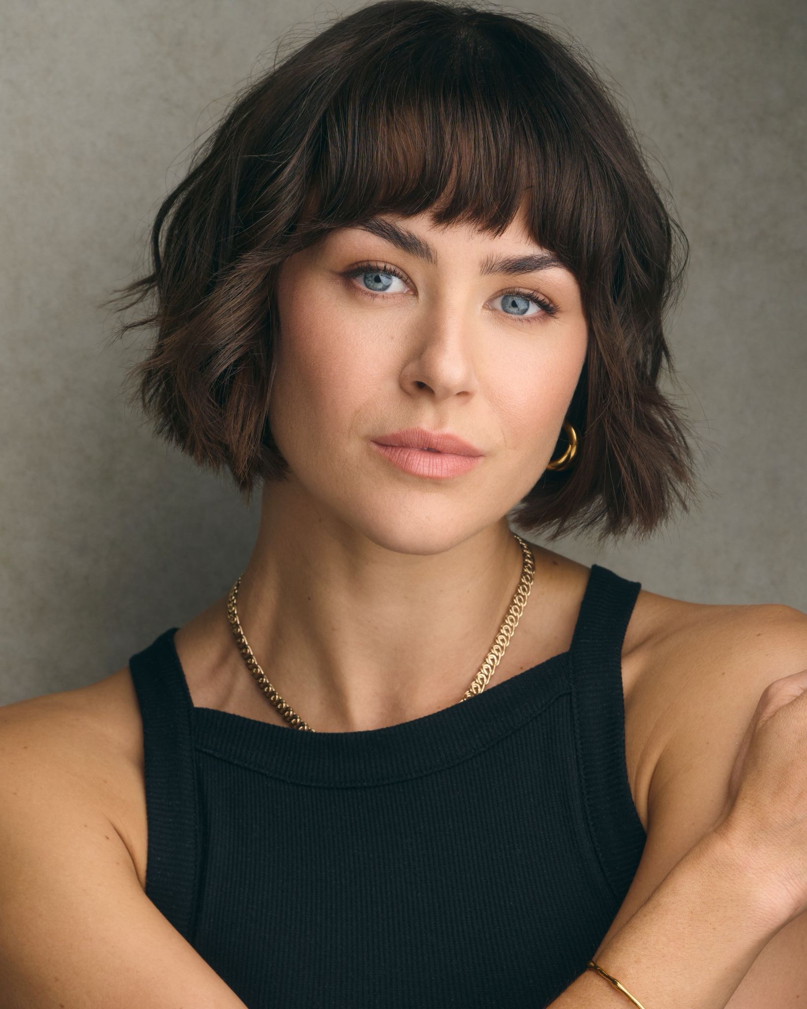 A headshot of a brunette woman with a bob haircut, looking directly at the camera