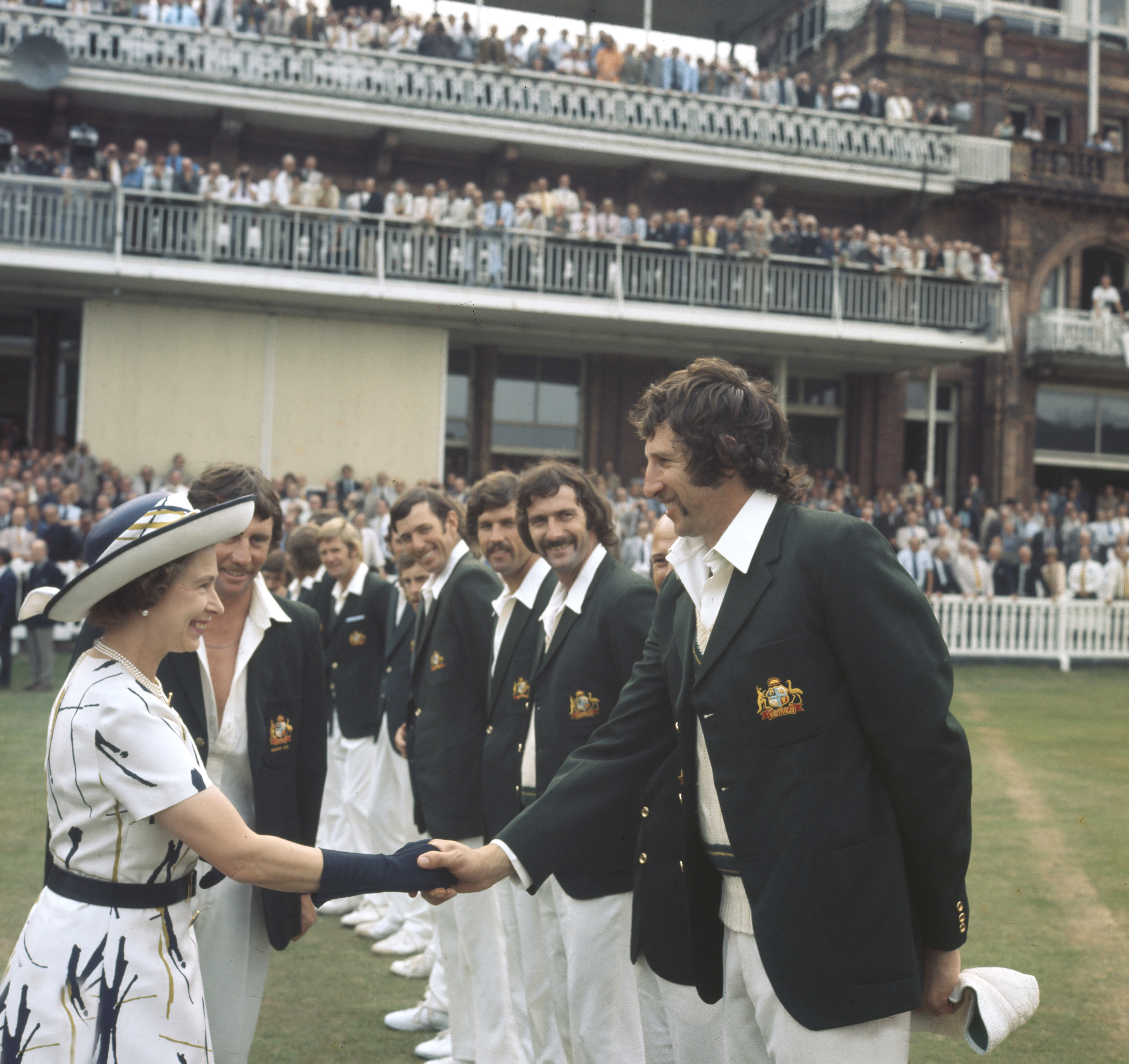 Queen Elizabeth shakes hands with cricket player Max Walker, and to his left is Dennis Lillee at Lords Cricket Ground in London on July 31, 1975