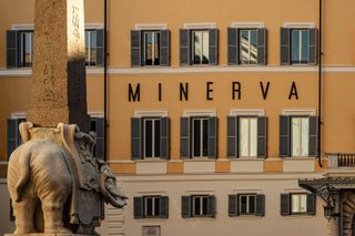 A concrete elephant statue stands in front of the Minerva exterior