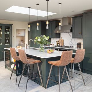 kitchen with black units and island with wooden chairs