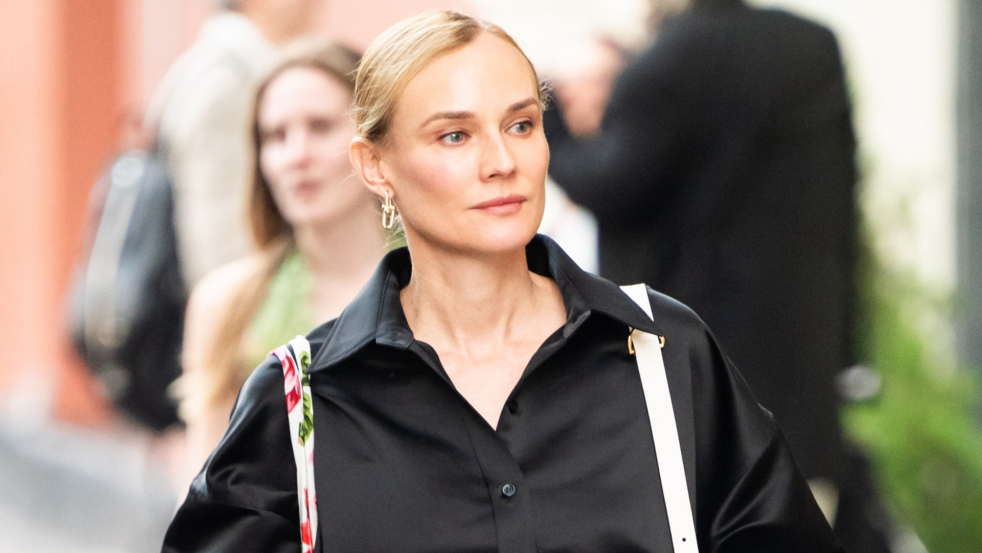 Diane Kruger wearing a black silky button-down shorts, black track shorts, and zebra-print heels in NYC