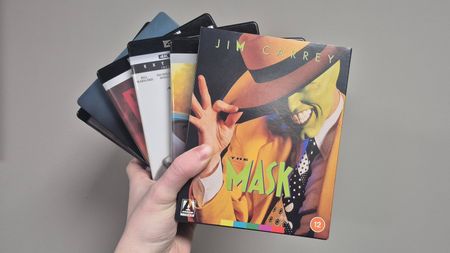 Man holding collection of 4K Blu-rays