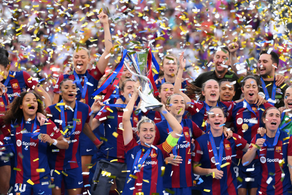 BILBAO, SPAIN - MAY 25: Alexia Putellas of FC Barcelona lifts the UEFA Women's Champions League Trophy as her team mates celebrate after the team's victory in the UEFA Women's Champions League 2023/24 Final match between FC Barcelona and Olympique Lyonnais at San Mames Stadium on May 25, 2024 in Bilbao, Spain.