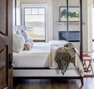 A bedroom with a coastal view, hardwood floor, a fireplace and artwork