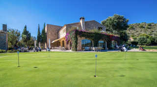 Practice putting green and clubhouse at Pula