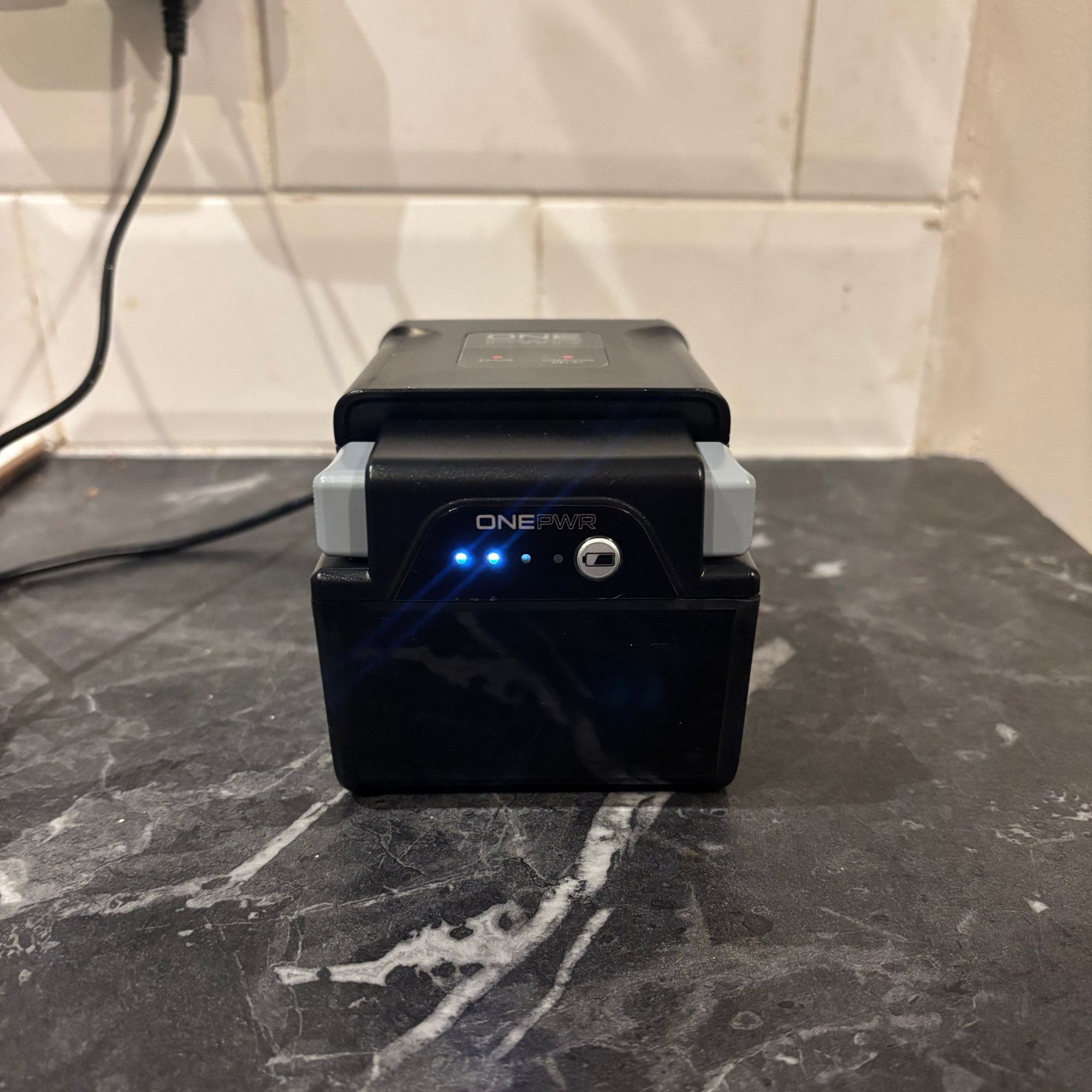 ONEPWR Cordless Compact Carpet Cleaner battery plugged in to charge