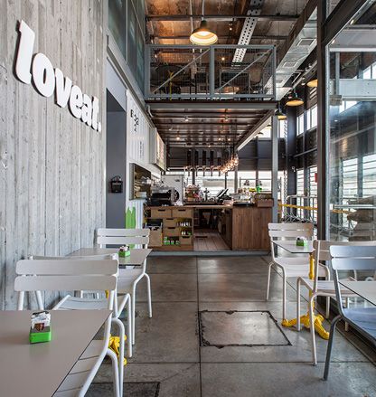 Love Eat Restaurant Interior which features white tabe tops and yellow legs &amp; white chairs 