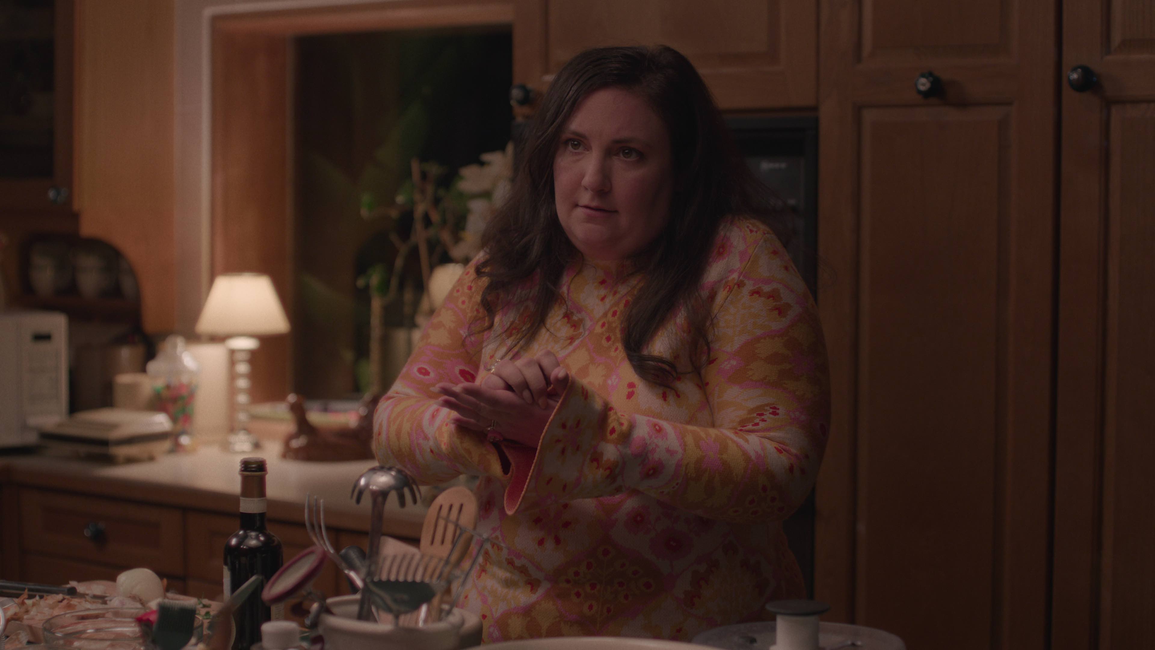 lena dunham standing in a kitchen in a still from the tv show too much