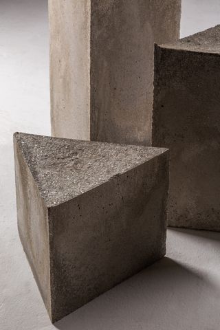 Triangular stone stools by Cristián Mohaded