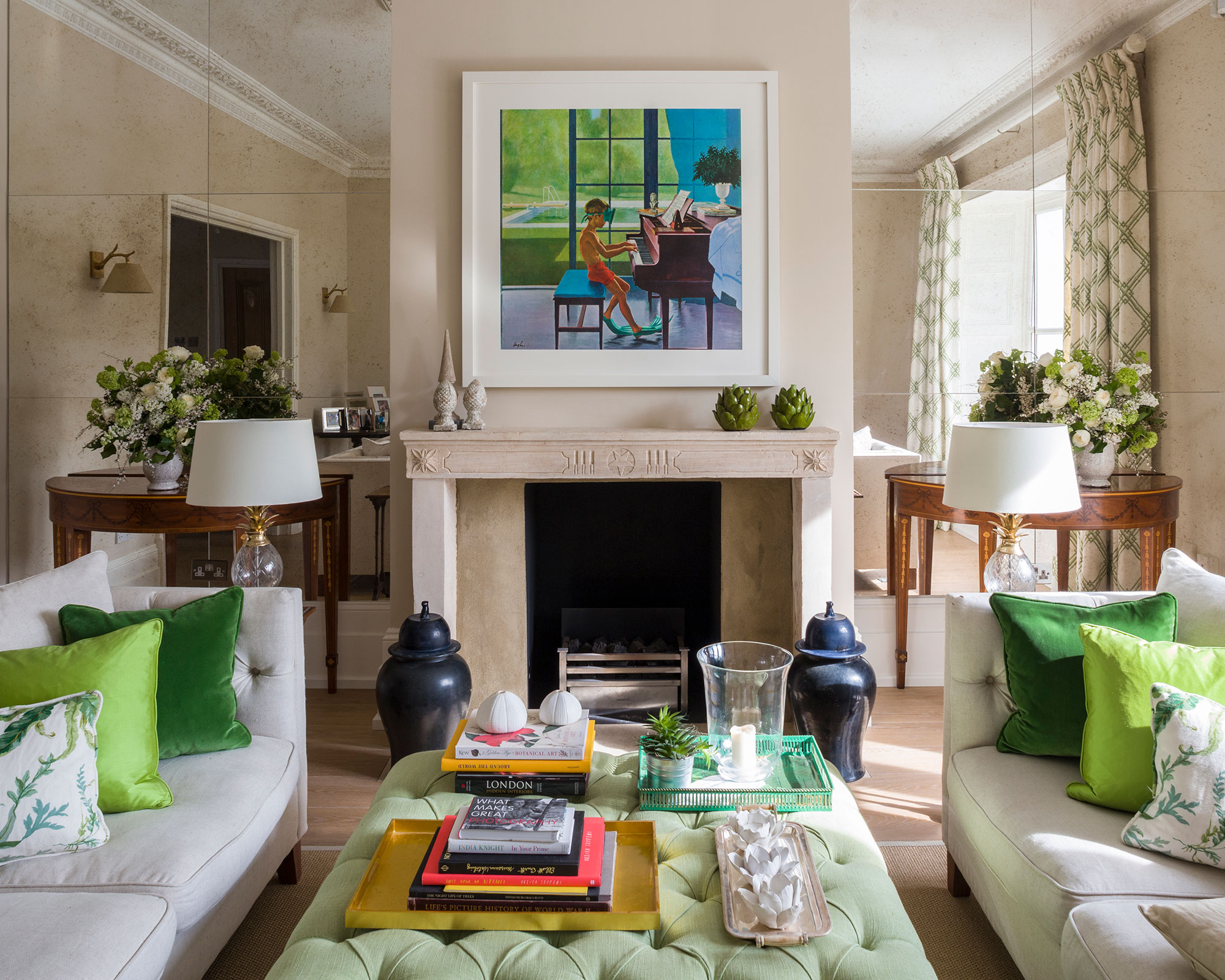 Beige living room with symmetrical green soft furnishings and mirrored walls.