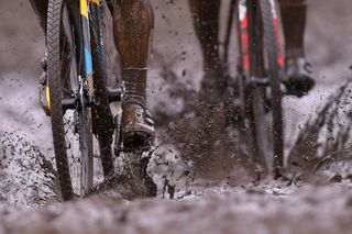 Cyclo-cross racers ride through muddy conditions