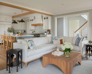 A modern farmhouse-style living room with a white sofa, and open-plan access to the kitchen