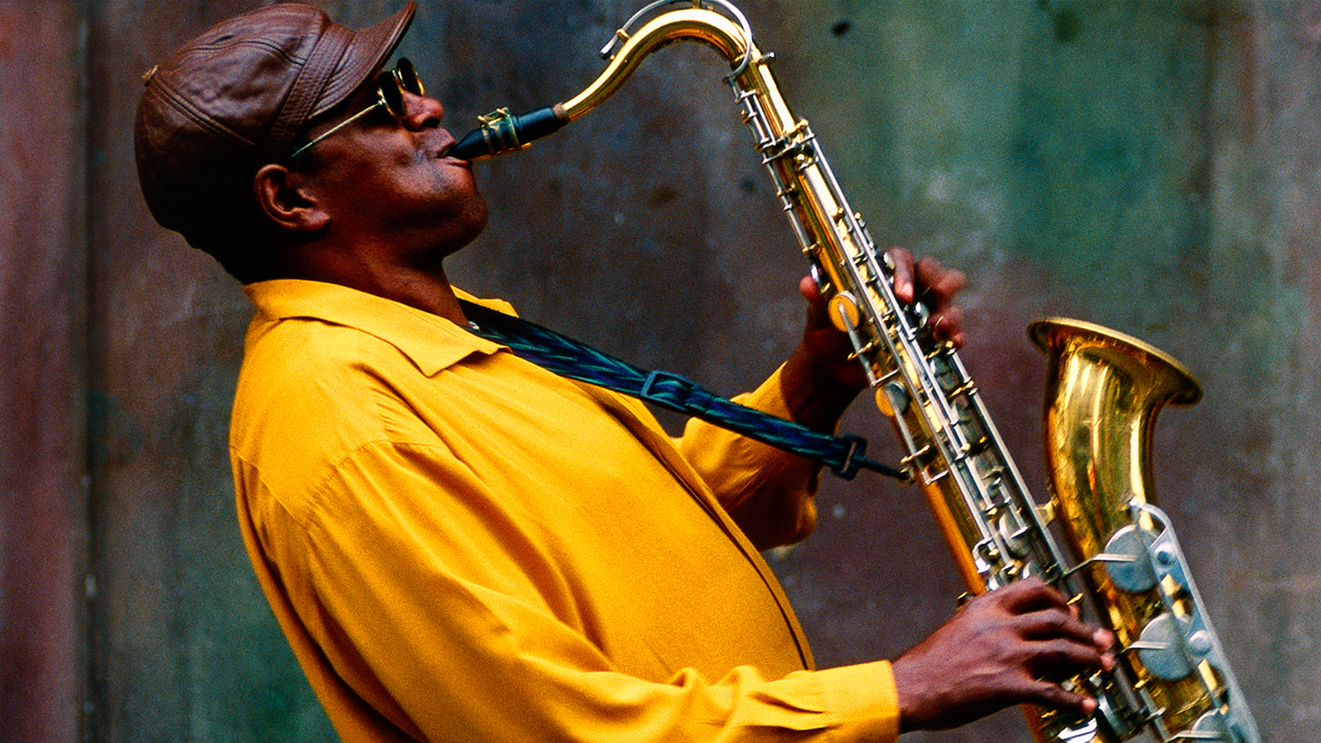 Man in yellow jacked playing saxophone